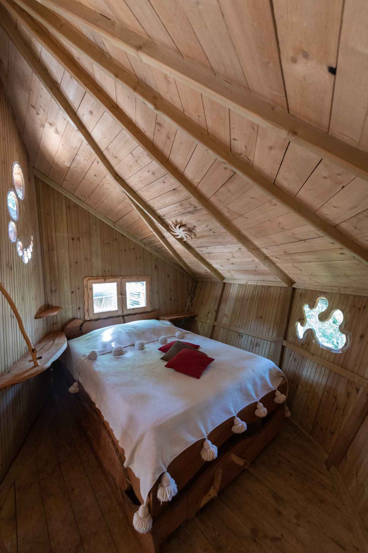 version-internet-37 castor Cabane en bois avec lit douillet et fenêtres rondes, au cœur de lAuvergne-Rhône-Alpes.