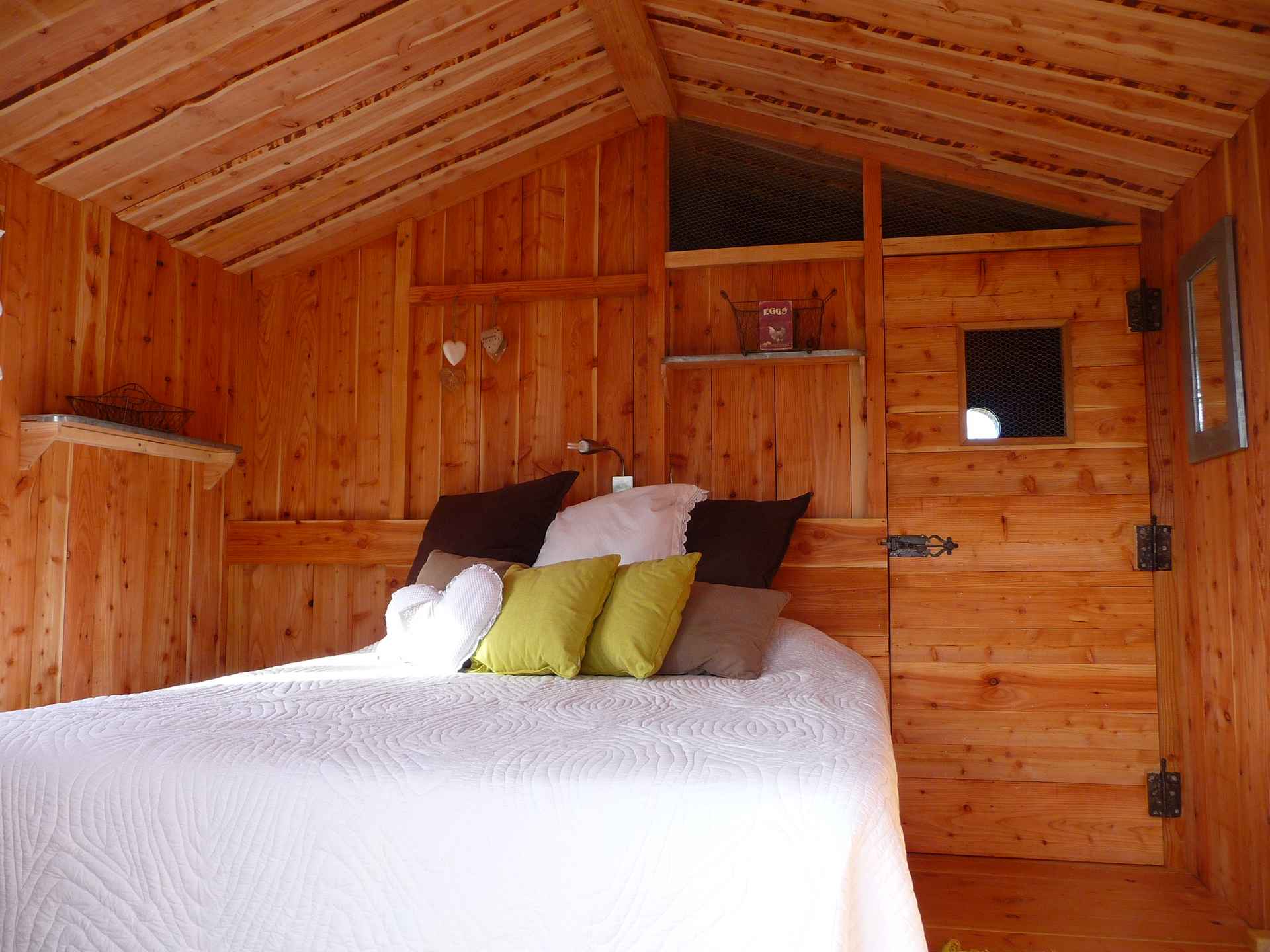 c1130712 (28) Chalet en bois chaleureux avec lit douillet et coussins colorés en Auvergne-Rhône-Alpes.