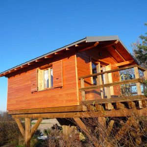 Cabane en bois perchée, offrant une vue dégagée sur la nature en Auvergne-Rhône-Alpes.