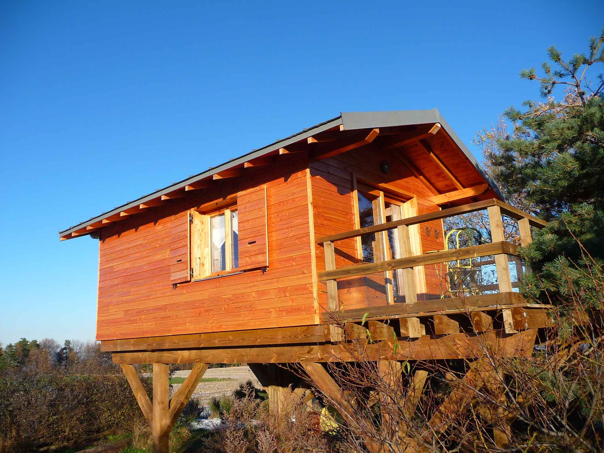 cabane ext 2911 Cabane en bois perchée, offrant une vue dégagée sur la nature en Auvergne-Rhône-Alpes.