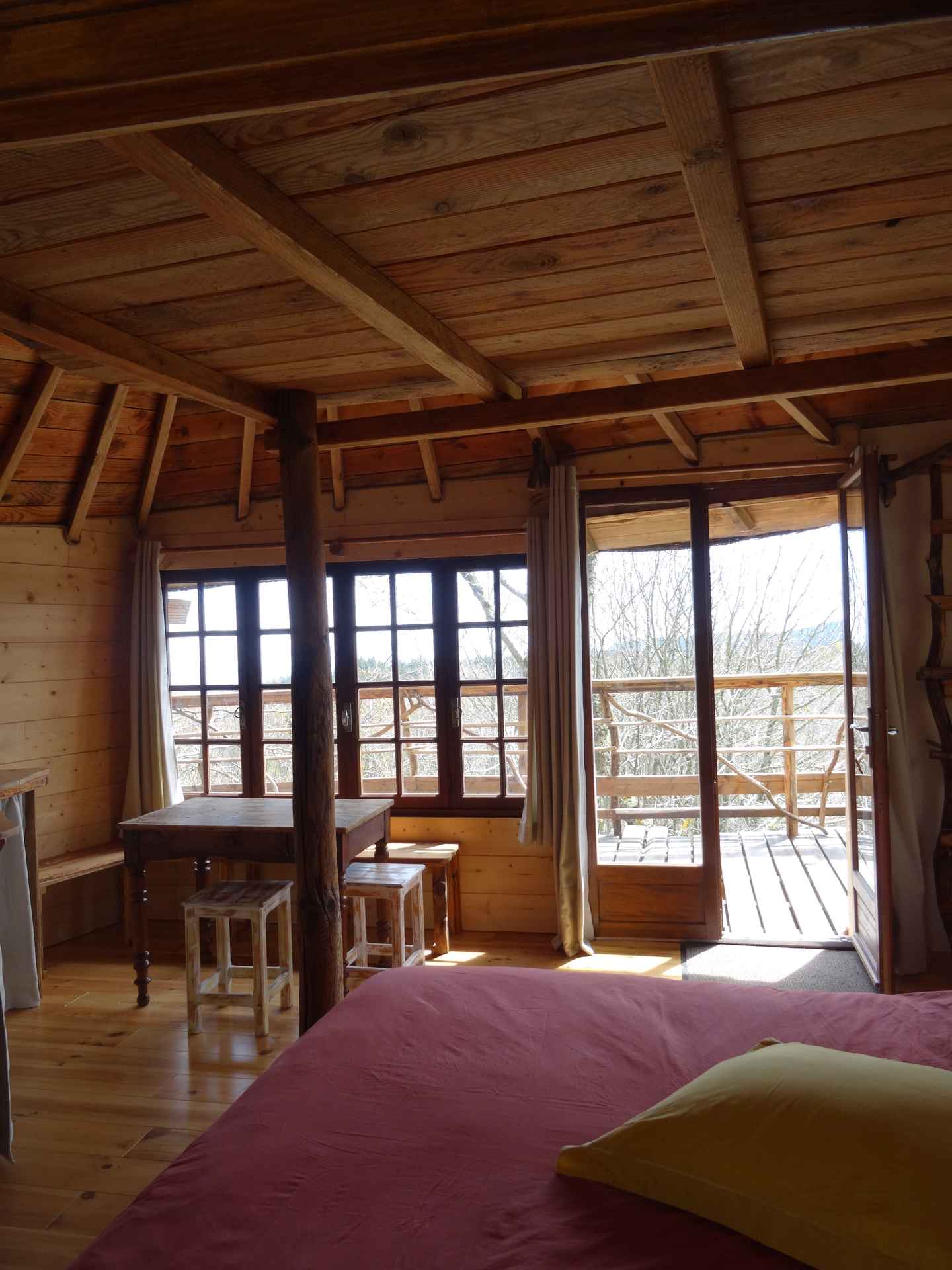 vue du lit Cabane en bois avec vue panoramique, lit confortable et table en bois.