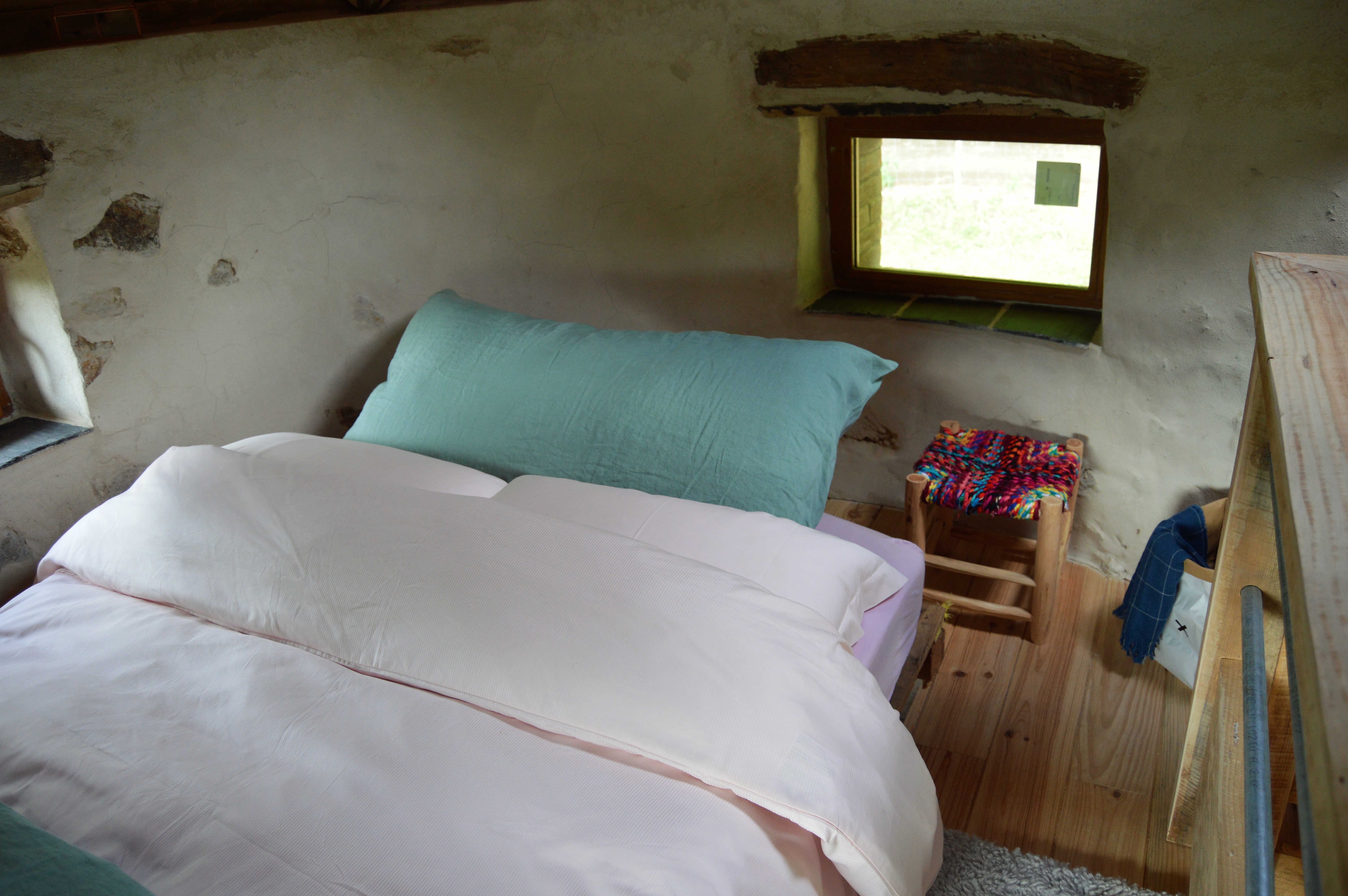 DSC_0332 Chambre cosy en cabane, avec lit douillet et fenêtre offrant une vue sur la nature.