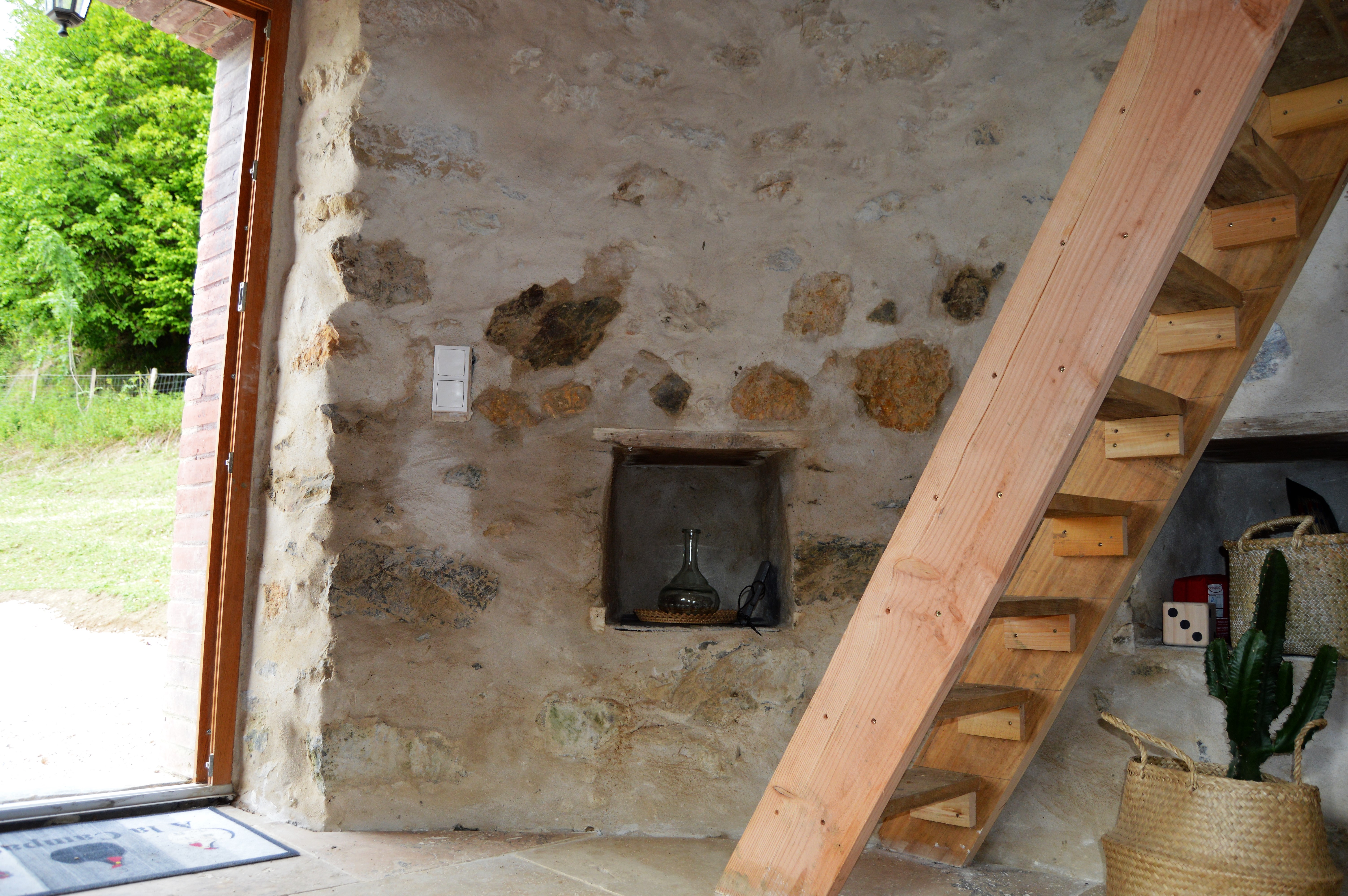 DSC_0407 Hébergement insolite en pierre avec un escalier en bois et une vue sur la nature.