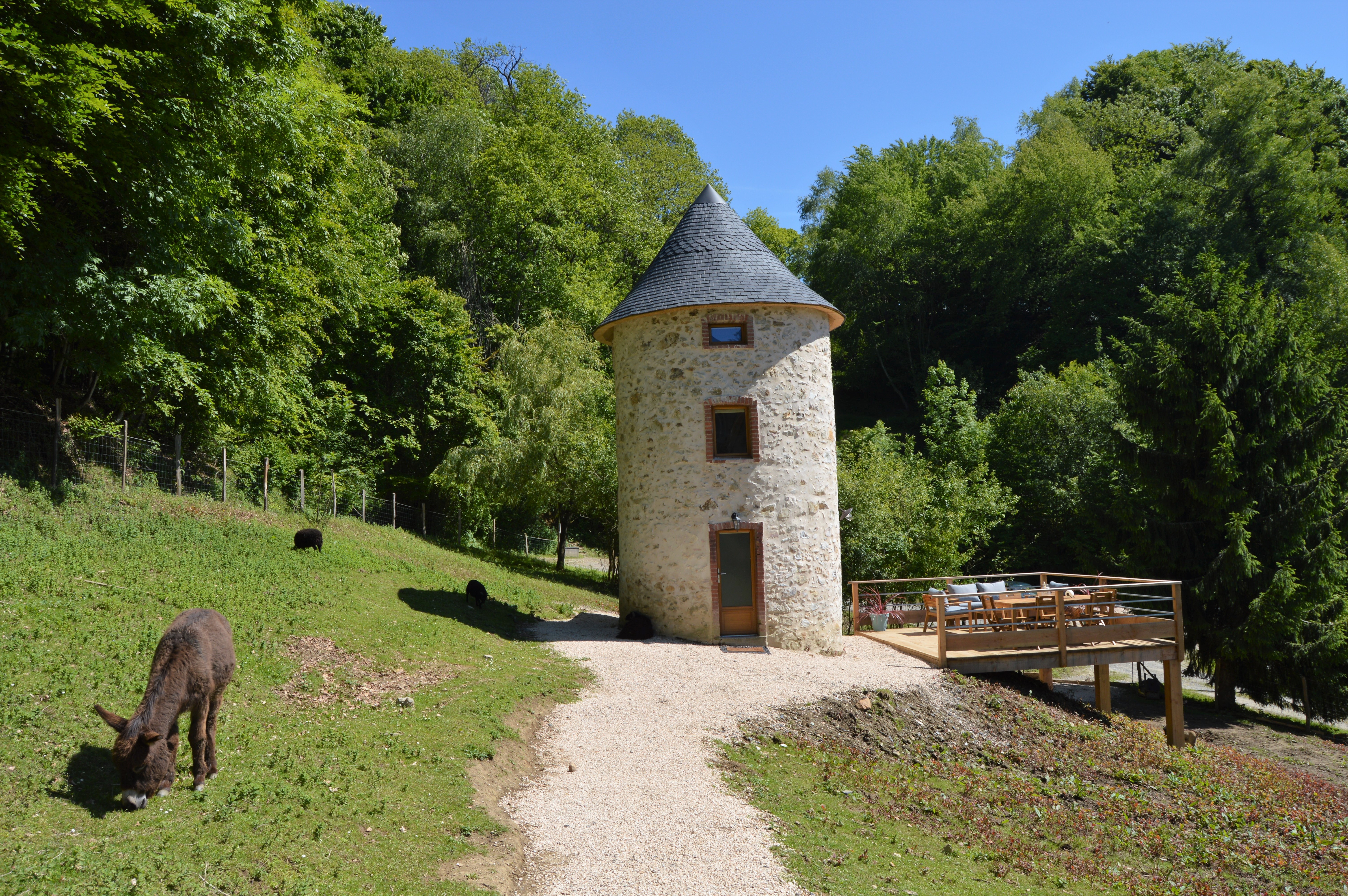 DSC_0439 Hébergement insolite en forme de tour, entouré de verdure et danimaux paisibles.