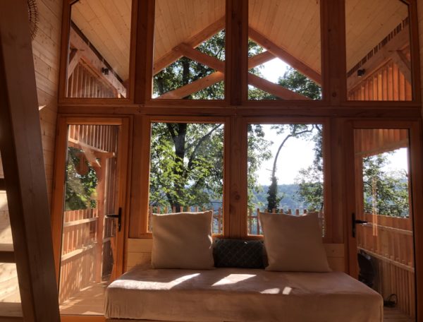 Cabane en bois avec grandes fenêtres, offrant une vue imprenable sur la nature.