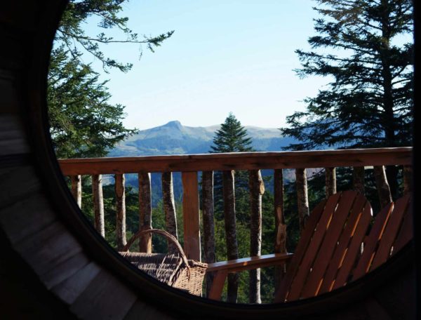 Cabane perchée en Auvergne avec vue panoramique sur les montagnes environnantes.