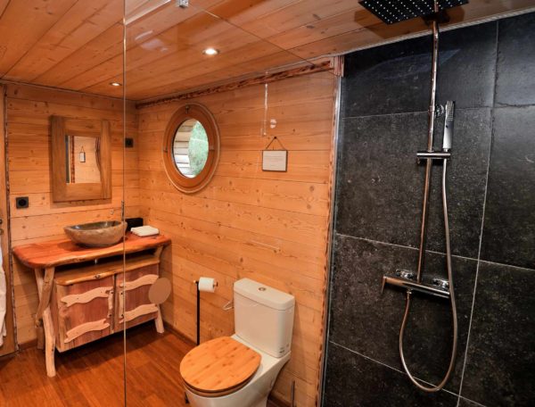 Salle de bain moderne en bois dans un hébergement insolite en Auvergne.