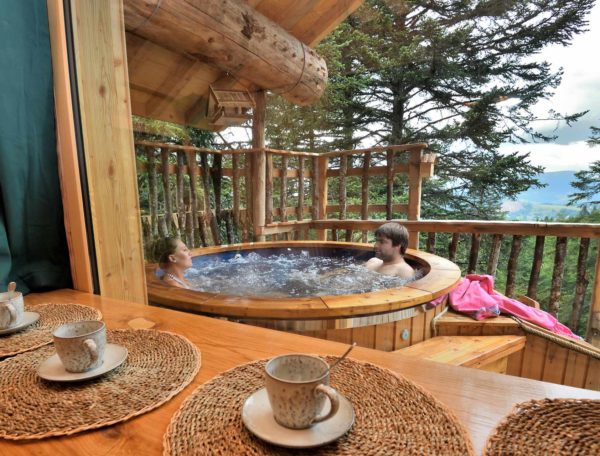 Cabane perchée en Auvergne avec jacuzzi extérieur et vue sur la nature.