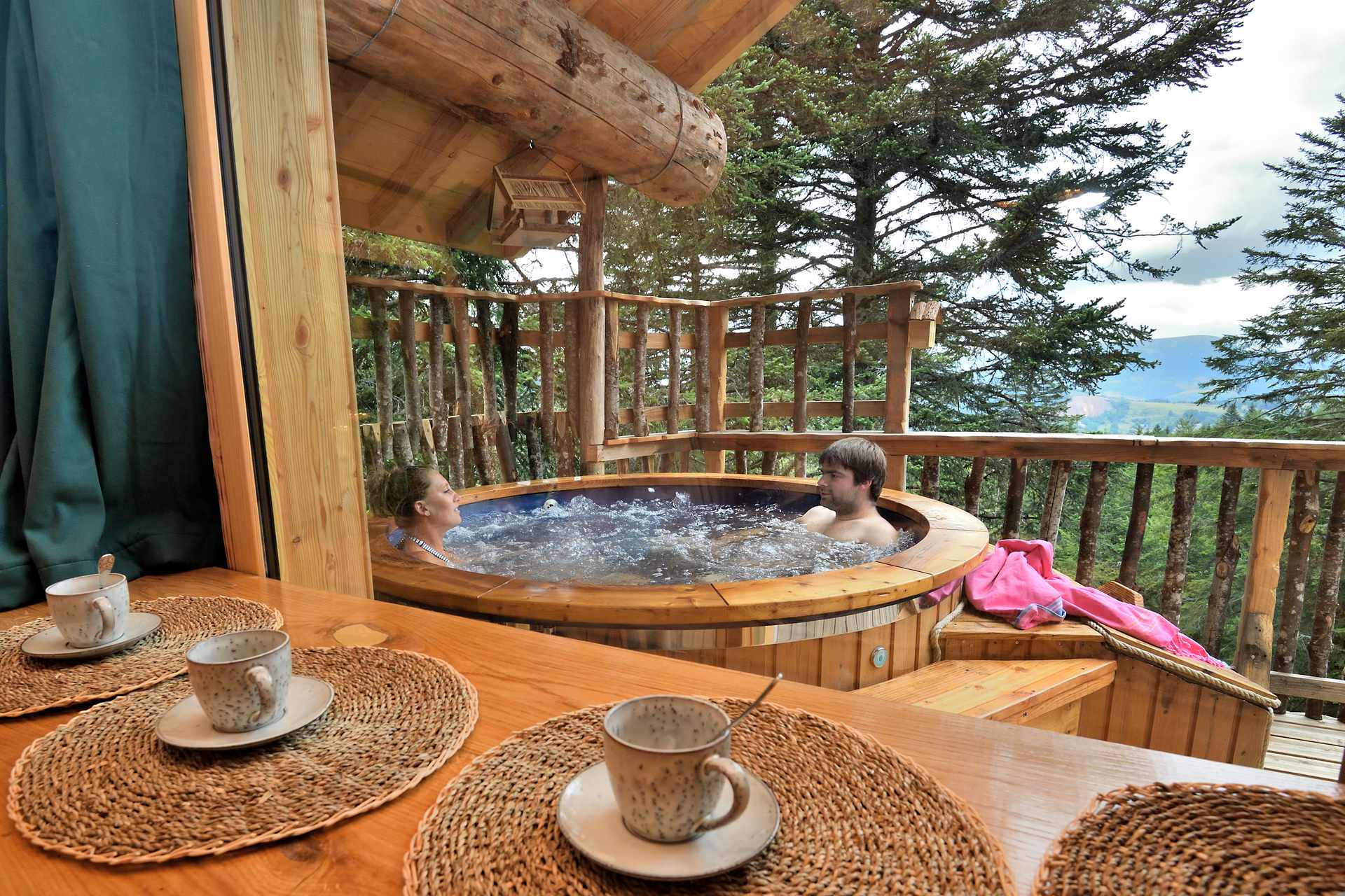 Cabane perchée en Auvergne avec jacuzzi extérieur et vue sur la nature.