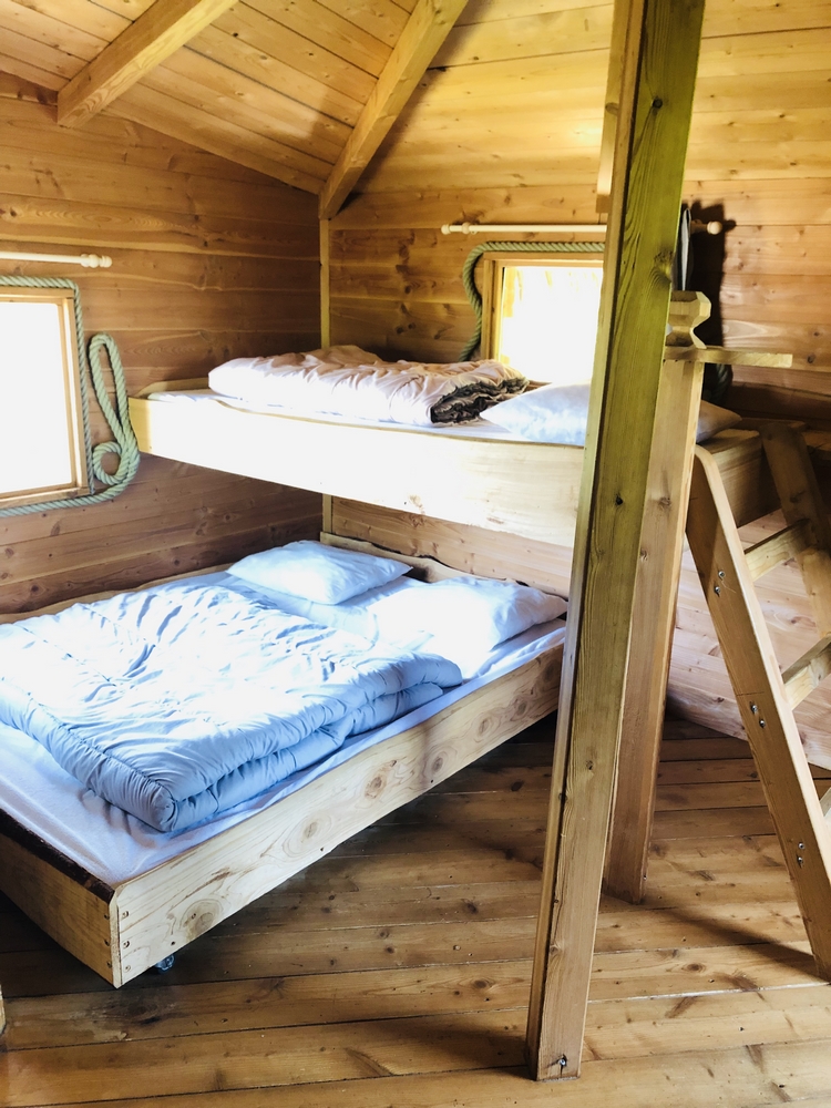 IMG_0843 Cabane en bois avec lits superposés et ambiance chaleureuse en Auvergne-Rhône-Alpes.