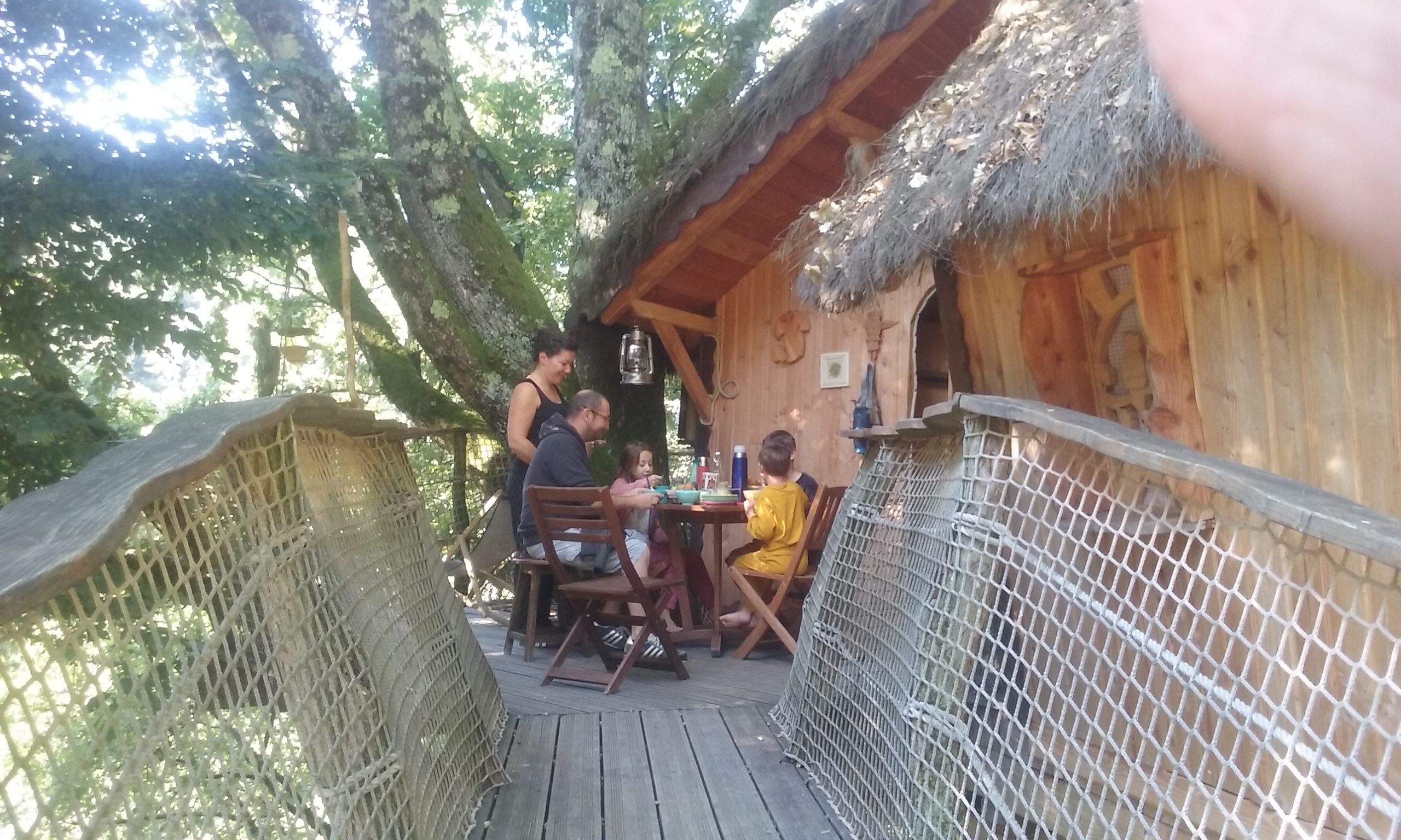 dossier n°1000(1) Cabane dans les arbres en Auvergne-Rhône-Alpes, avec terrasse en bois et famille réunie.