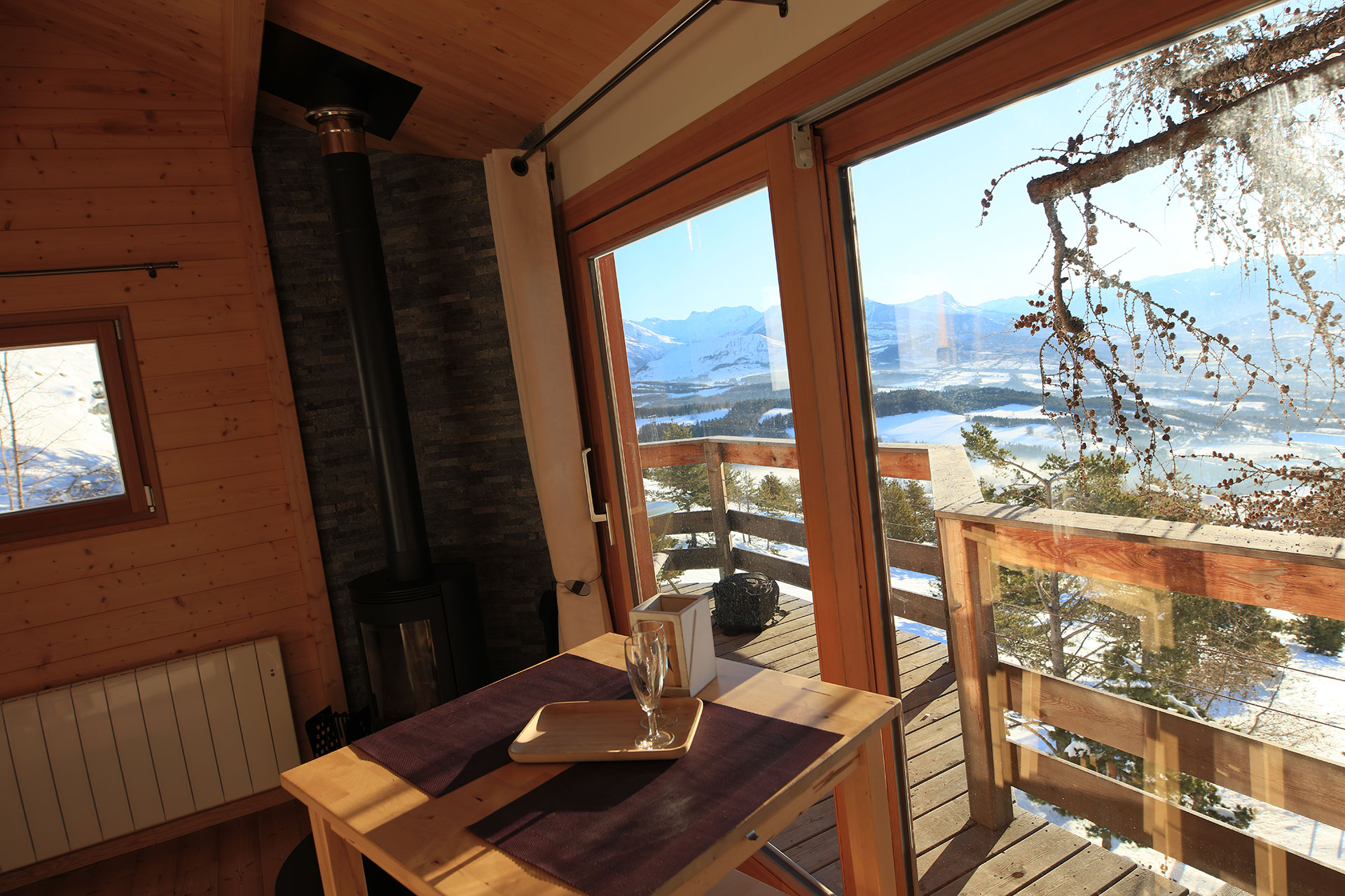 Cabane en bois avec vue panoramique sur les montagnes et un coin repas cosy.