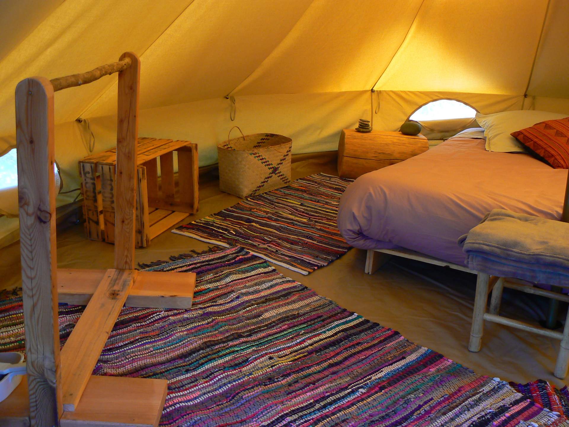P1100046 Tente glamping cosy avec lit douillet et tapis coloré, au cœur du Languedoc-Roussillon.