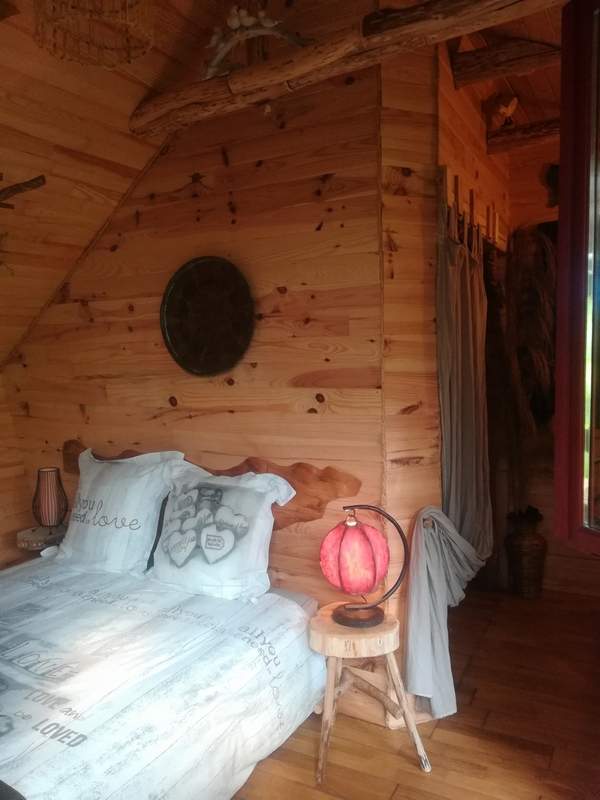 Nid 2020 interieur 1 Chalet en bois chaleureux avec lit douillet et décoration rustique à Basse-Normandie.