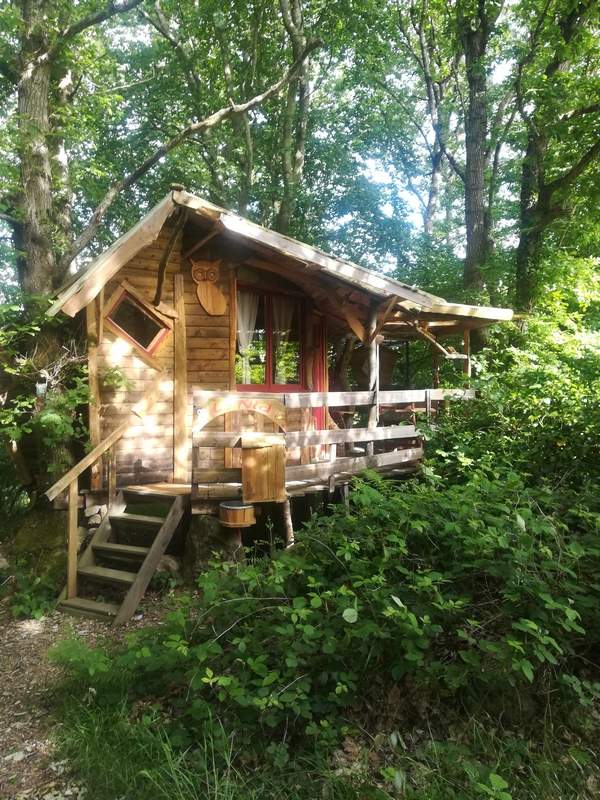 nid2020 exterieur 1 Cabane en bois nichée dans la verdure, avec une terrasse accueillante.
