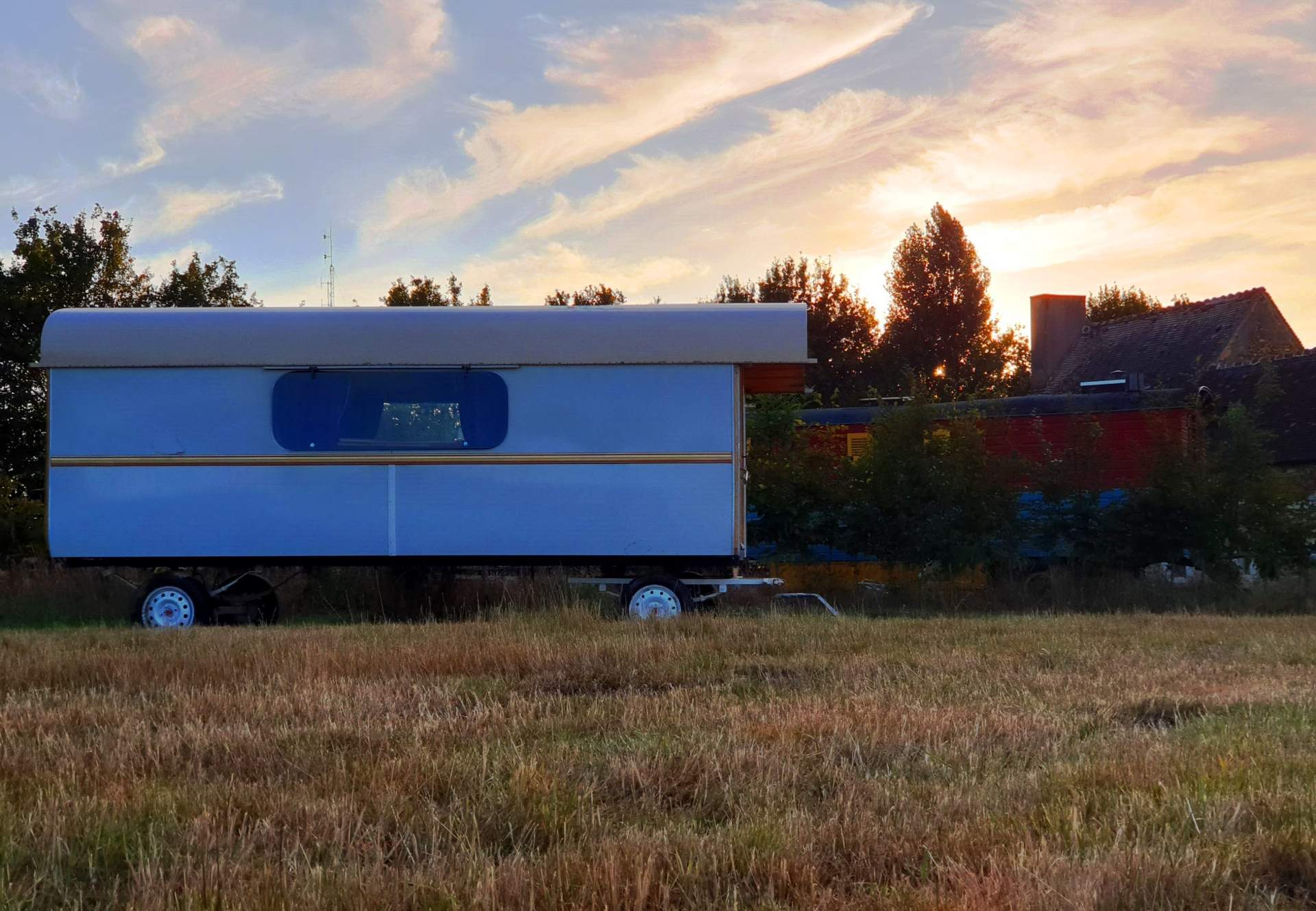 2020.07.11- Roulotte Gitane 2 Caravane insolite au coucher de soleil, entourée de verdure et de champs dorés.