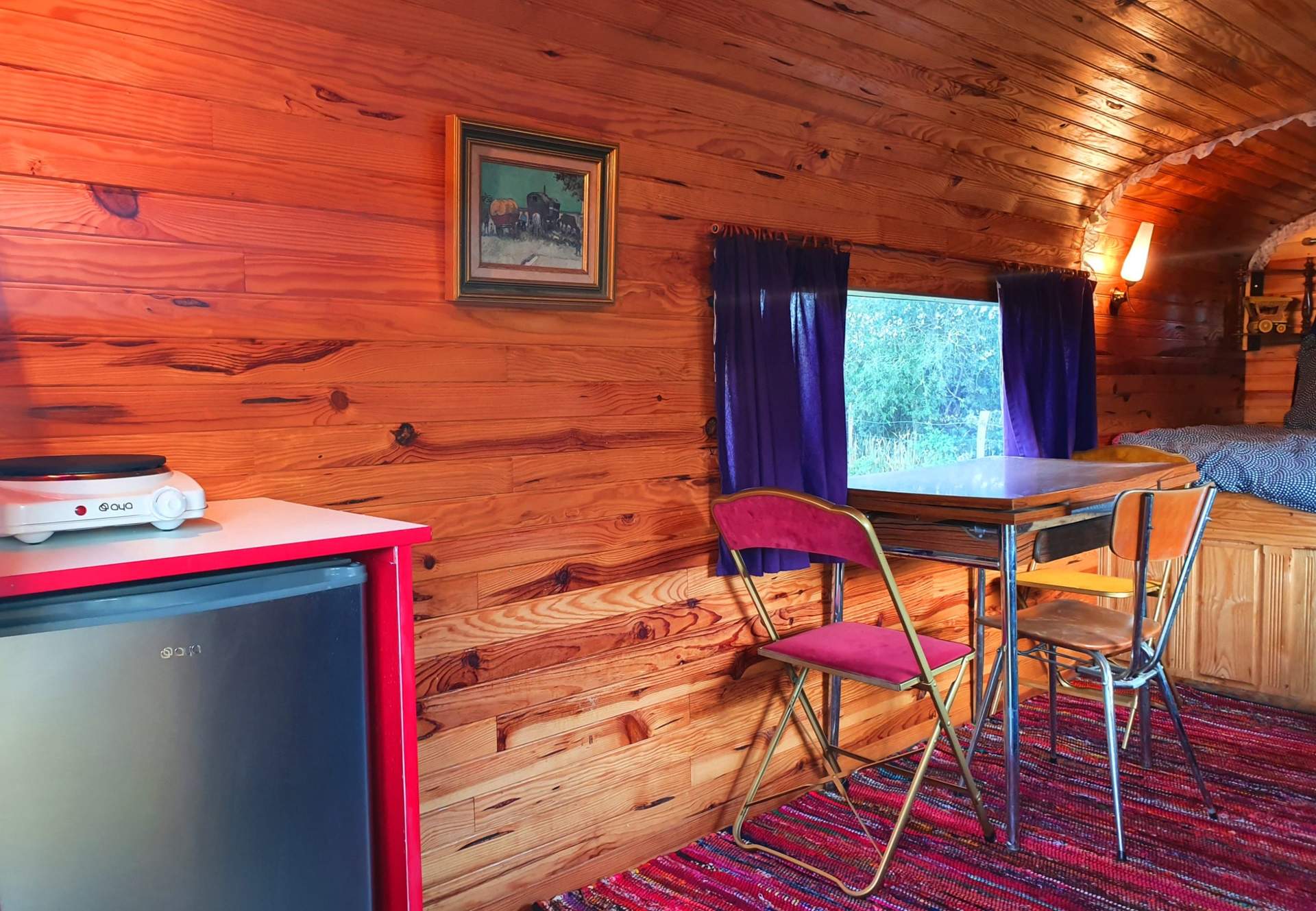 2020.07.11- Roulotte Gitane 4 Hébergement insolite en bois avec un coin repas et une vue sur la nature.