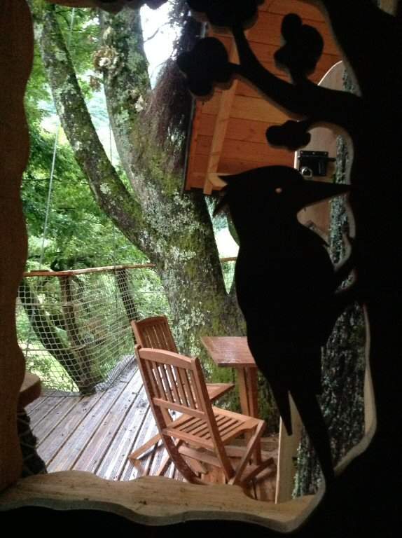 2014-07-09 20.05.47 Cabane perchée en Auvergne-Rhône-Alpes, vue sur la terrasse en bois entourée darbres.