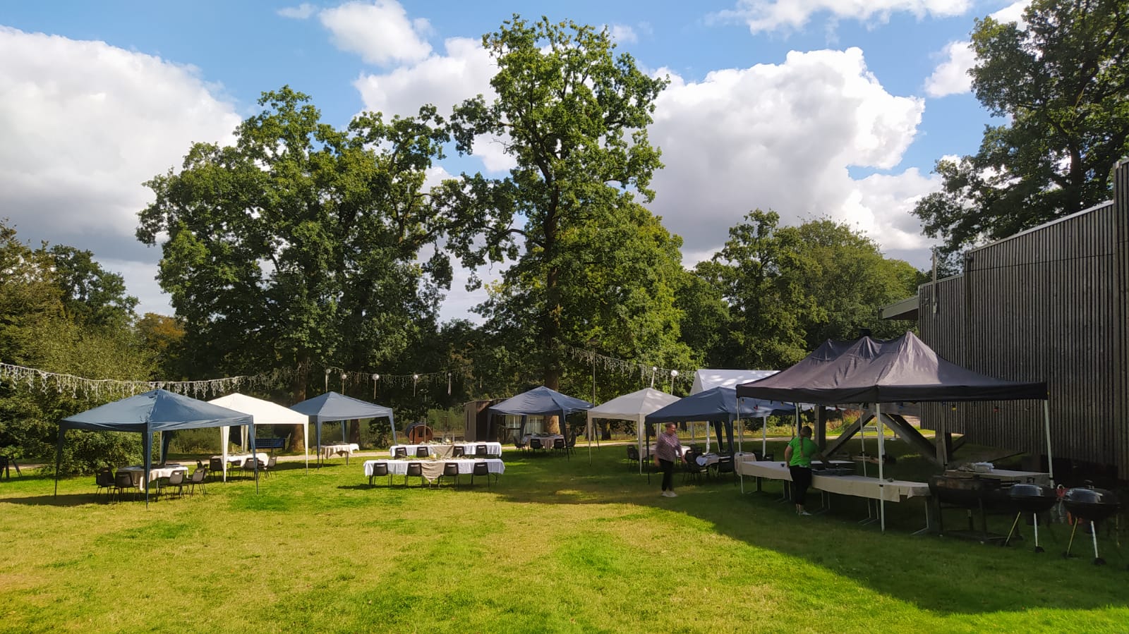 organisation evenement etape Hébergement insolite en Basse-Normandie, avec tentes et tables sous de grands arbres.