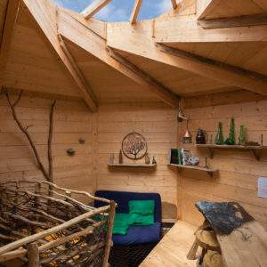 Cabane en bois avec un plafond en bois lumineux et une décoration naturelle.