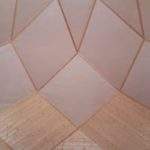 Intérieur dun hébergement en bois, avec un plafond géométrique lumineux.