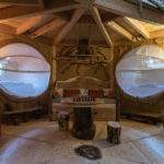 Cabane en bois avec fenêtres rondes et mobilier en bois naturel. Ambiance chaleureuse.