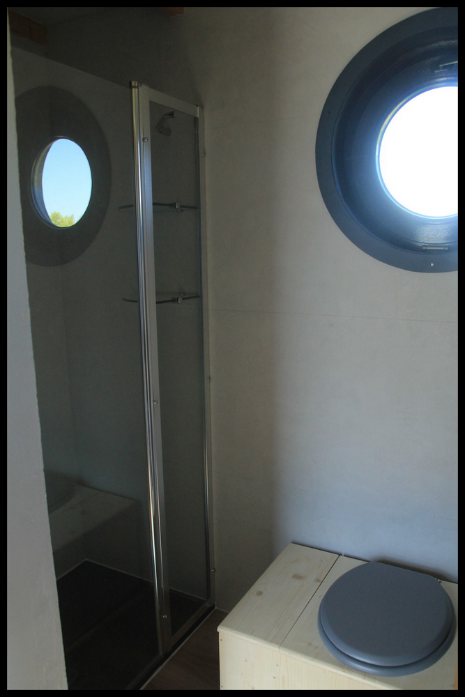 13 Salle de bain dun hébergement insolite en Midi-Pyrénées avec fenêtre ronde.