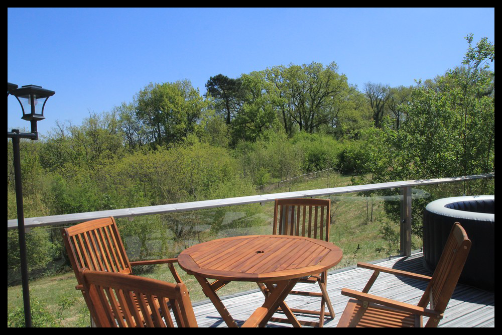 4 Hébergement insolite en Midi-Pyrénées avec terrasse en bois et vue sur la nature verdoyante.