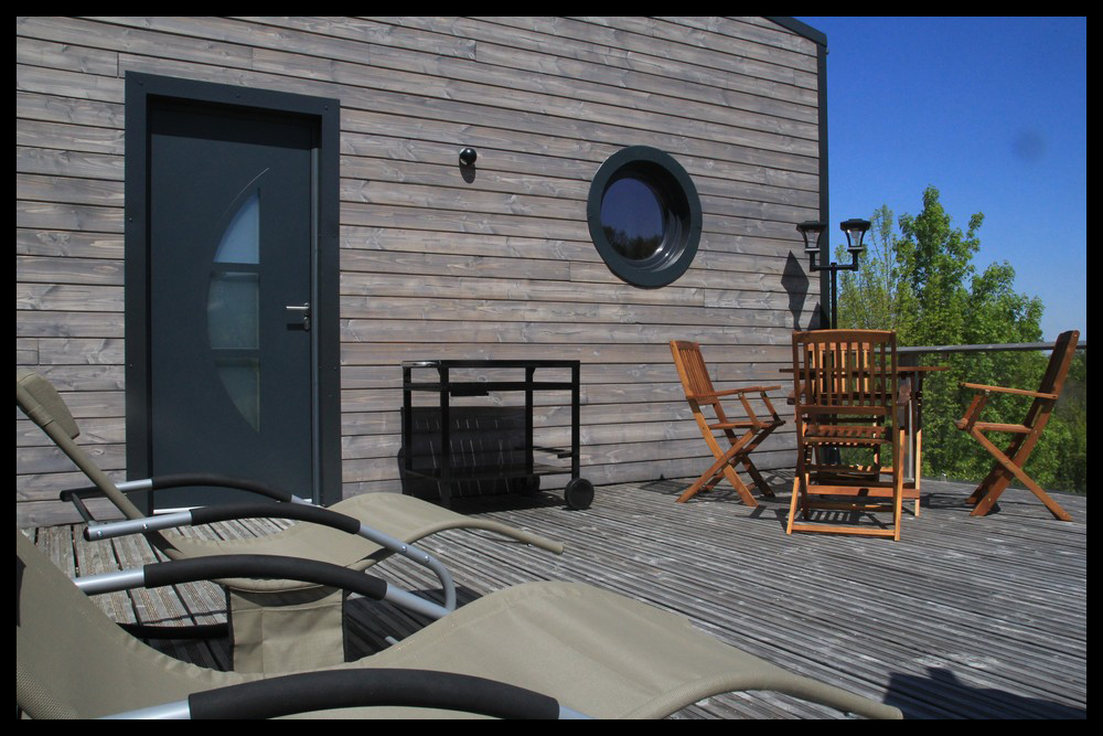 7 Hébergement insolite en Midi-Pyrénées, avec terrasse en bois et chaises longues confortables.