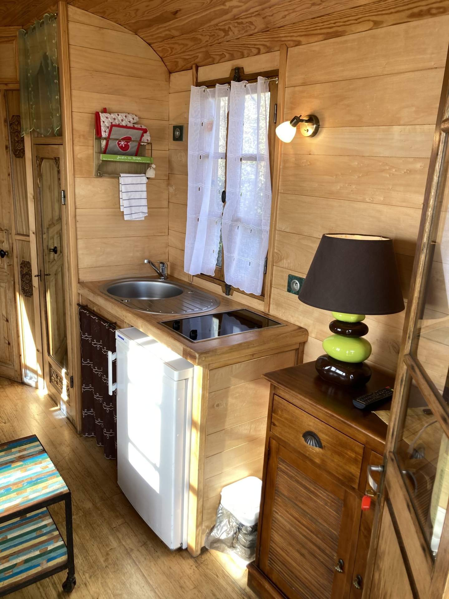 IMG_1614 Charmante roulotte en bois avec kitchenette et lumière douce, idéale pour un séjour unique.