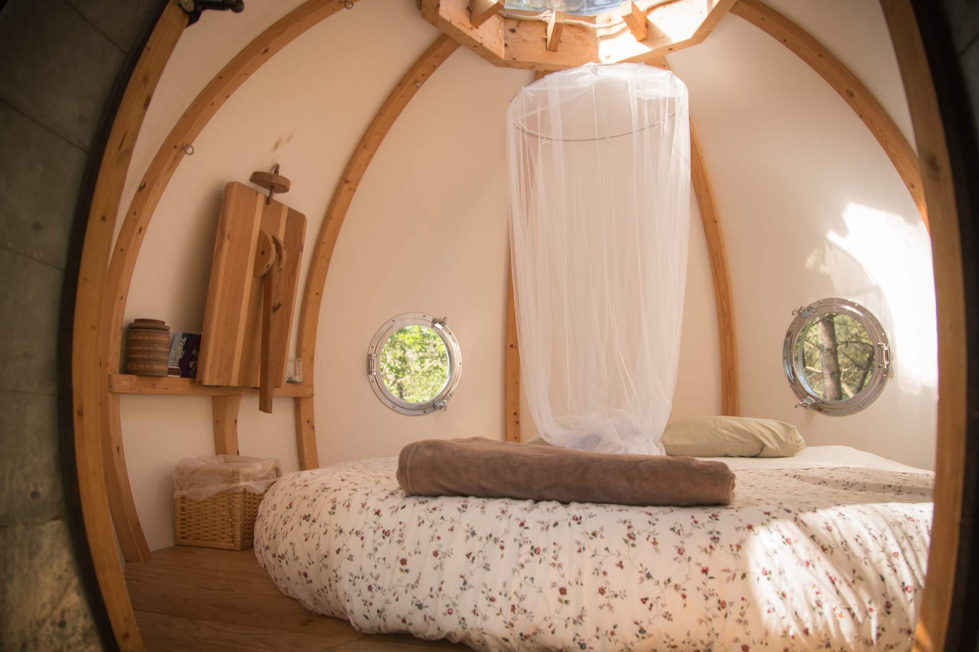 studio4k14 Hébergement insolite en Bretagne : cabane ronde avec lit douillet et fenêtres arrondies.