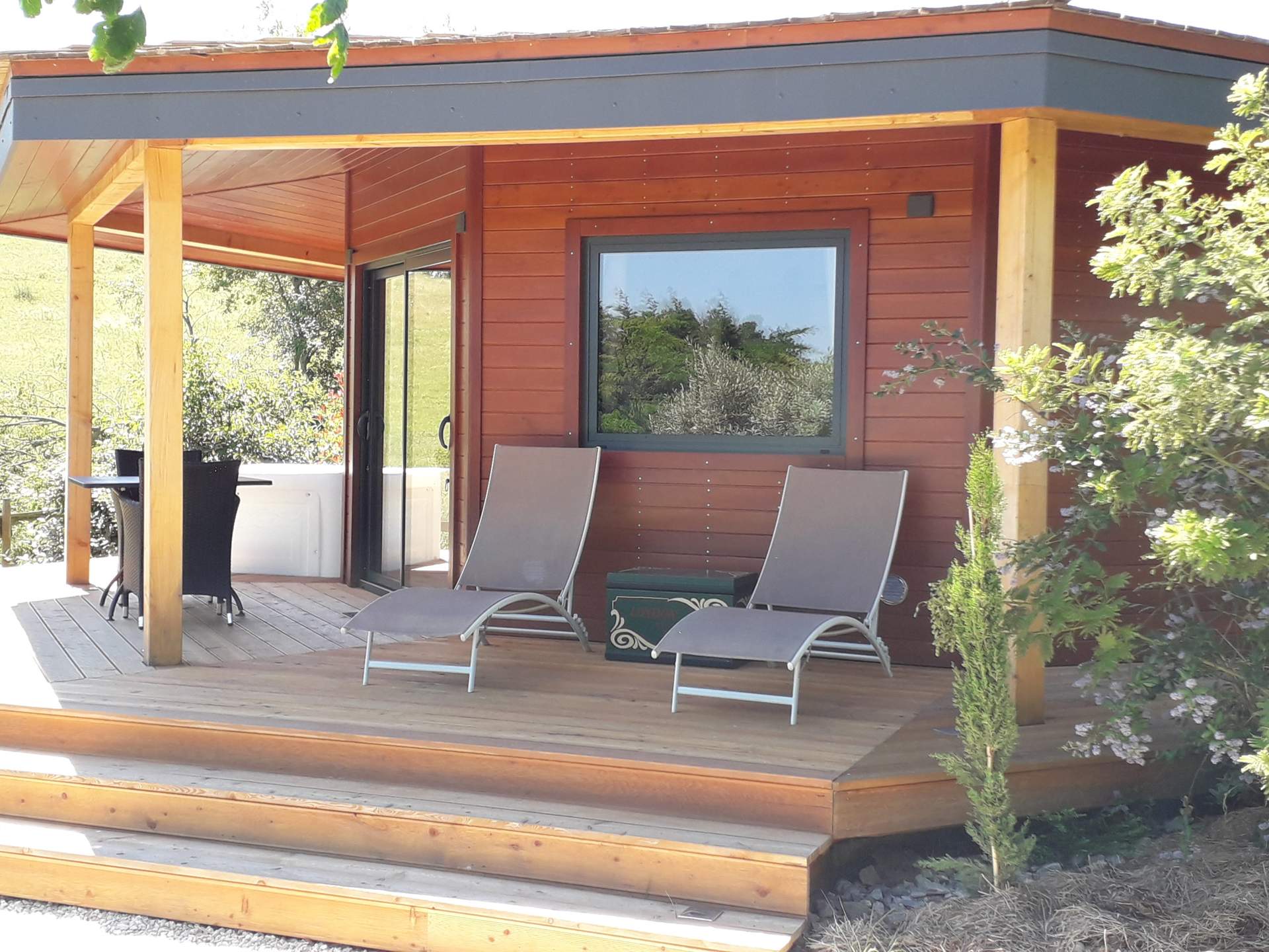 20210610_153809 Cabane en bois avec terrasse ensoleillée et chaises longues à Languedoc-Roussillon.