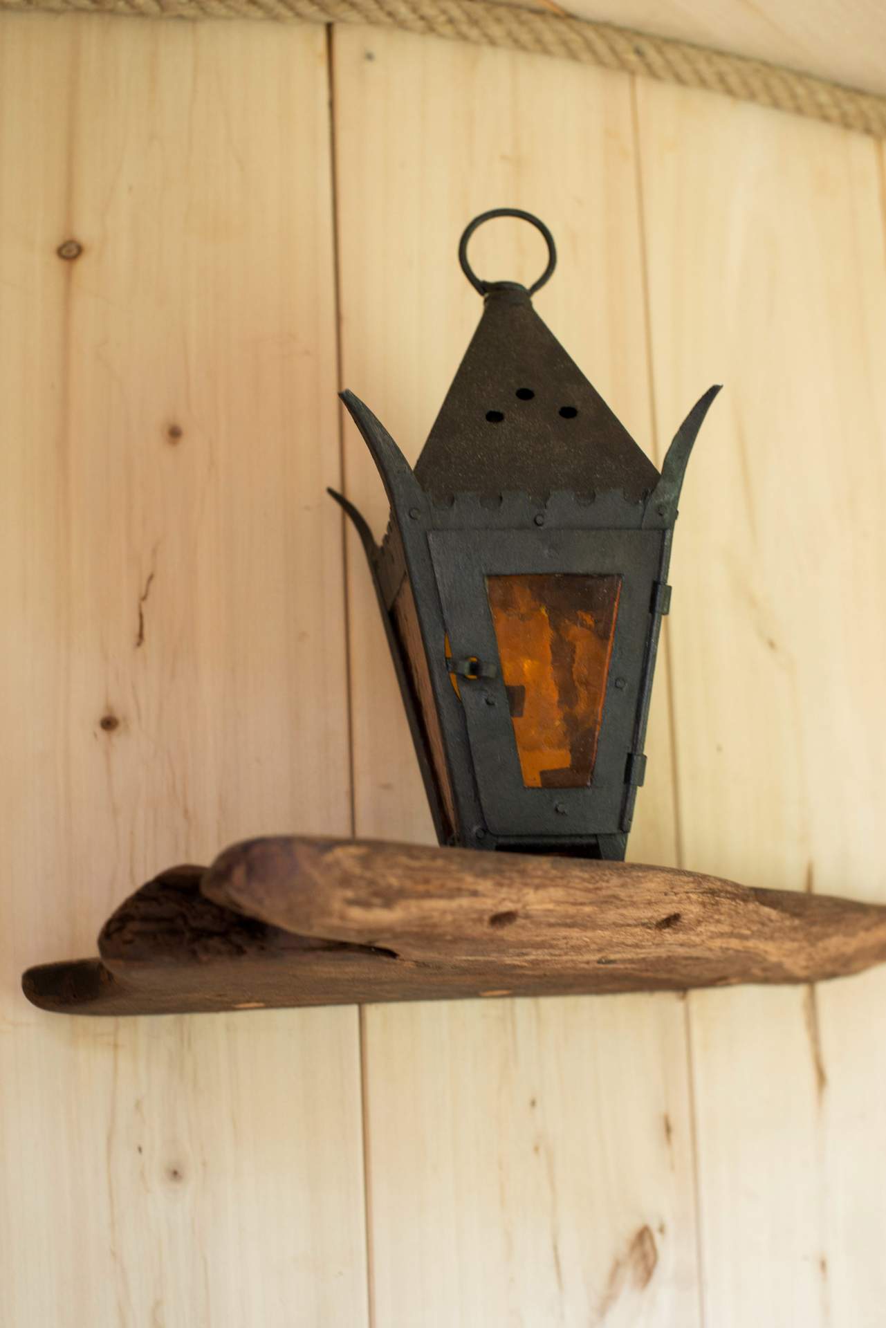 000_6080 Lanterne vintage en métal sur étagère en bois dans un hébergement insolite en Bourgogne.