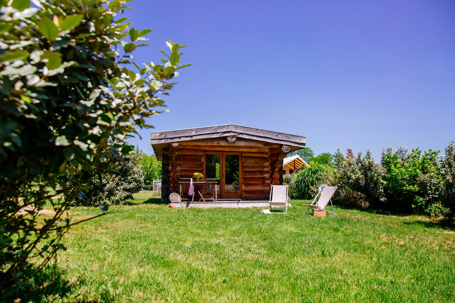Cabane de Trappeur 2 Cabane en bois dans un jardin verdoyant, idéale pour un séjour insolite en Aquitaine.