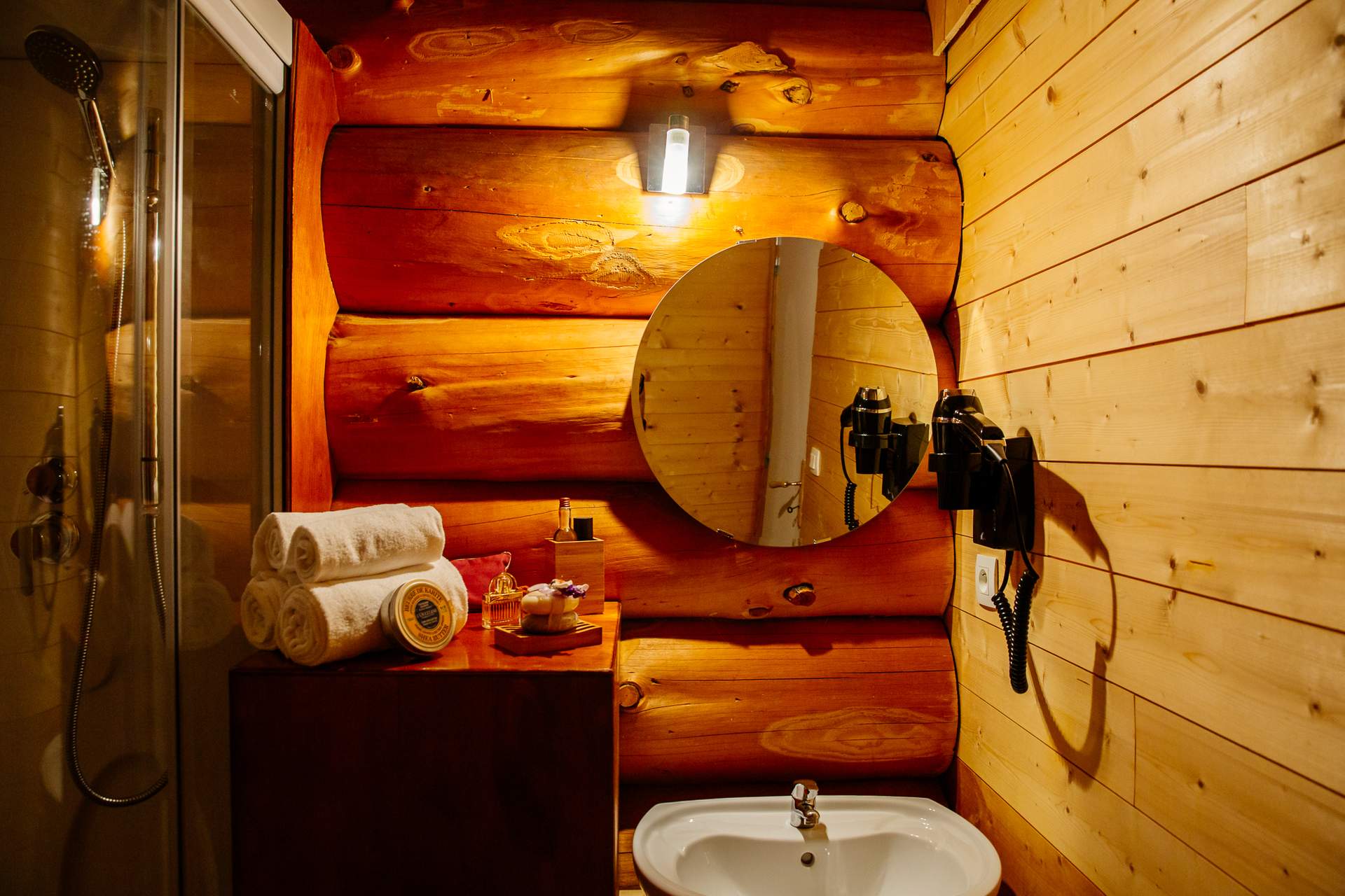 Cabane de trappeur 6 Salle de bain en bois dans un hébergement insolite en Aquitaine, avec miroir rond.
