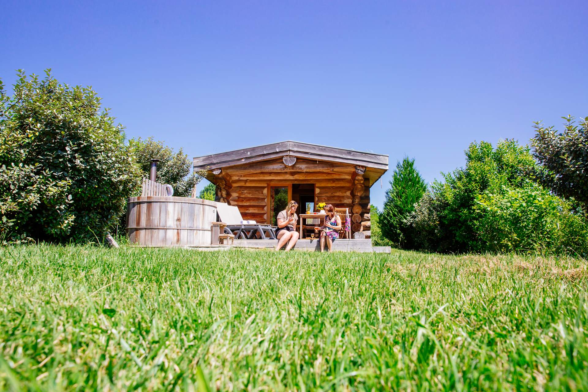 Cabane de trappeur spa 2 Cabane en bois avec jacuzzi, entourée de verdure en Aquitaine. Détente au soleil.