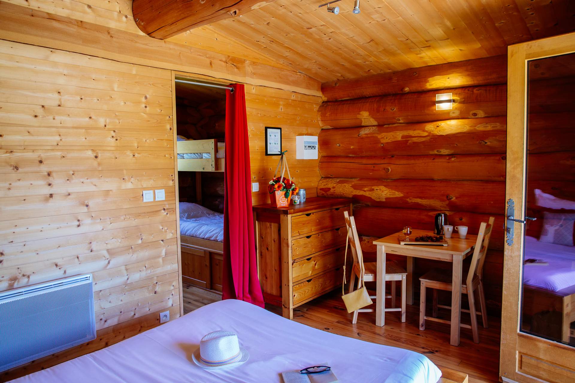 Cabane de trappeur spa 5 Chalet en bois chaleureux avec lit confortable et coin repas lumineux.
