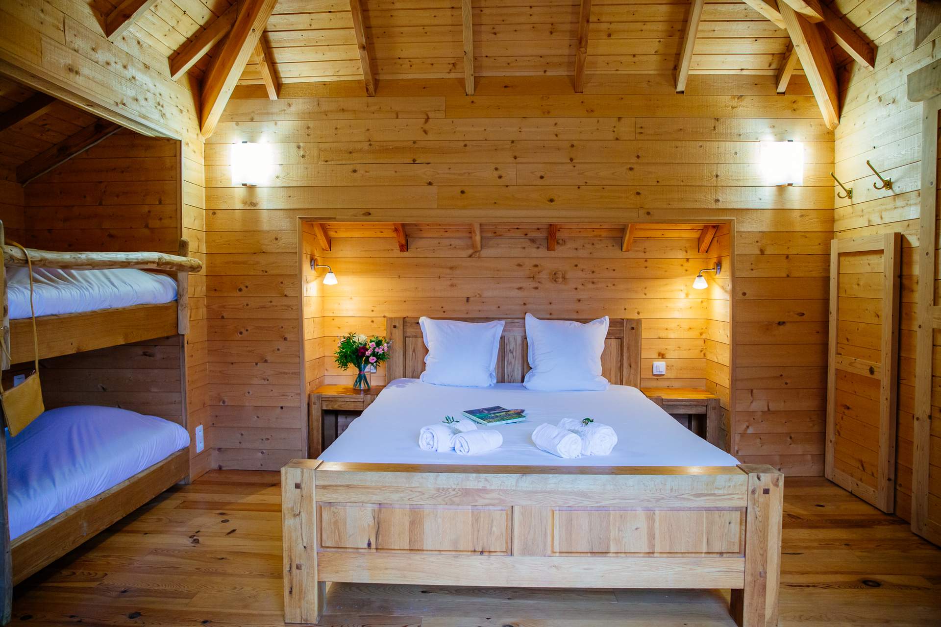 Chateau dans les arbres 4 Chalet en bois chaleureux avec lit double et lits superposés, ambiance cosy.