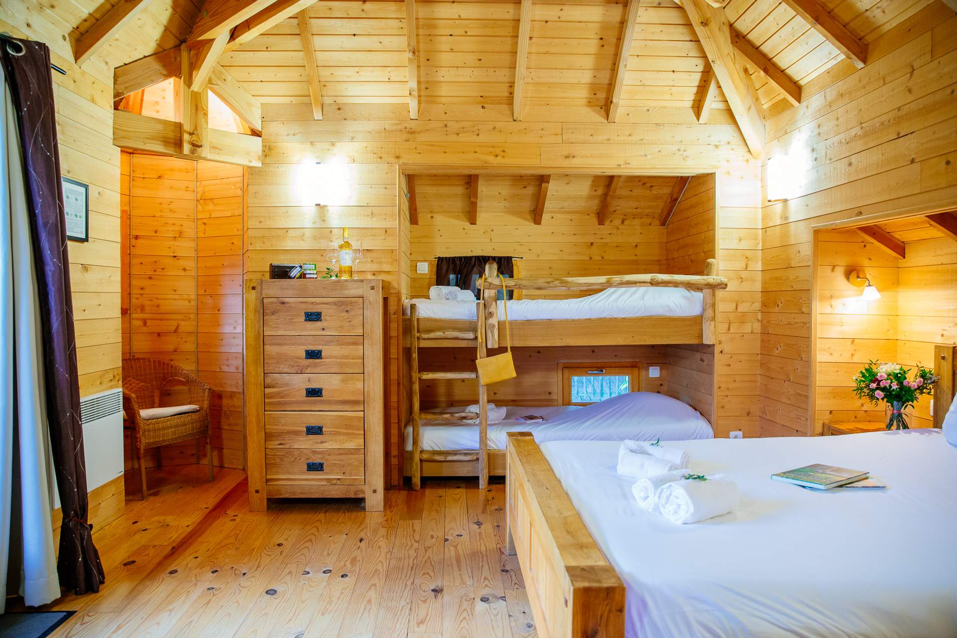 Chateau dans les arbres 5 Chalet en bois chaleureux avec lits superposés et décoration en bois naturel.