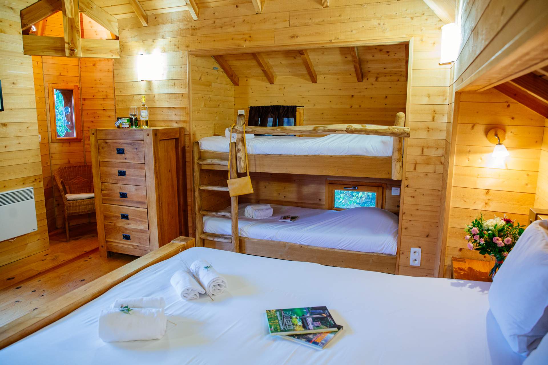 Chateau dans les arbres 7 Chalet en bois chaleureux avec lits superposés et décoration naturelle.