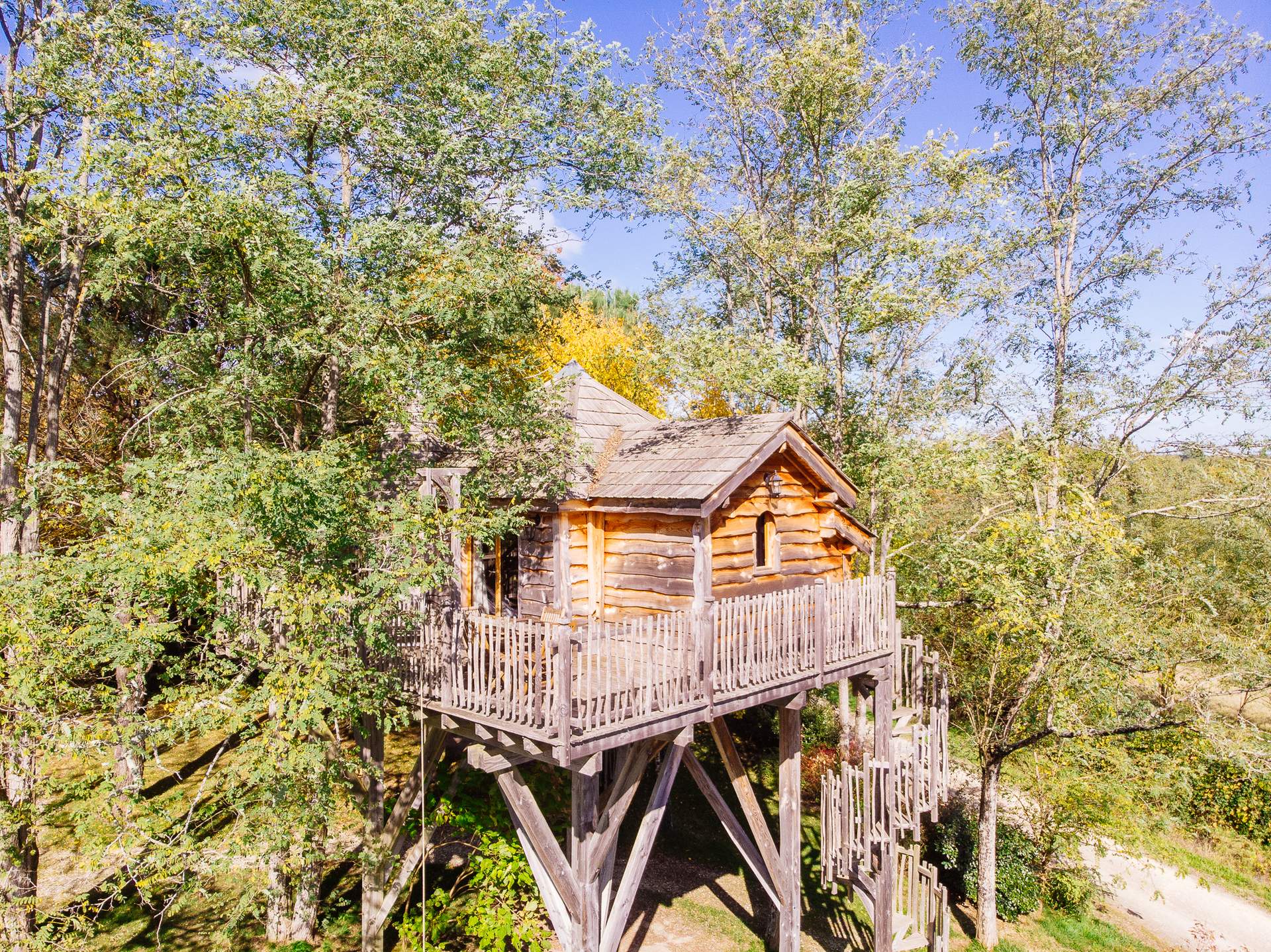 Chateau dans les arbres 8 Cabane en bois perchée dans les arbres, entourée de verdure en Aquitaine.