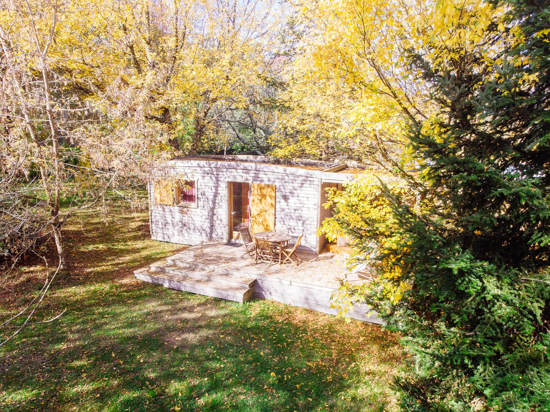 Oenolodge avec spa 10 Cabane en bois dans les arbres, entourée de feuillage doré en Aquitaine.