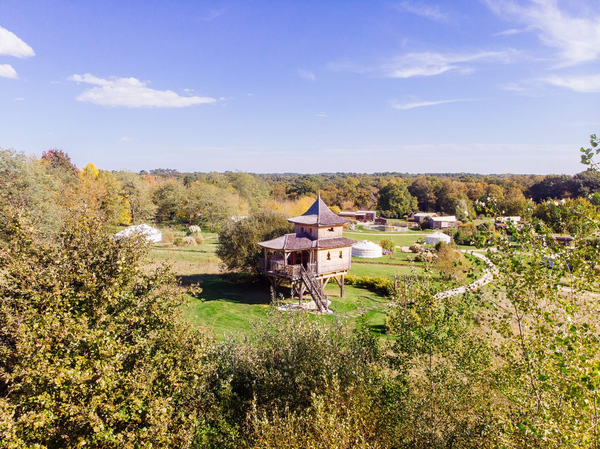 Temple perche avec spa 10 Cabane perchée en bois avec un toit pointu, entourée de verdure en Aquitaine.