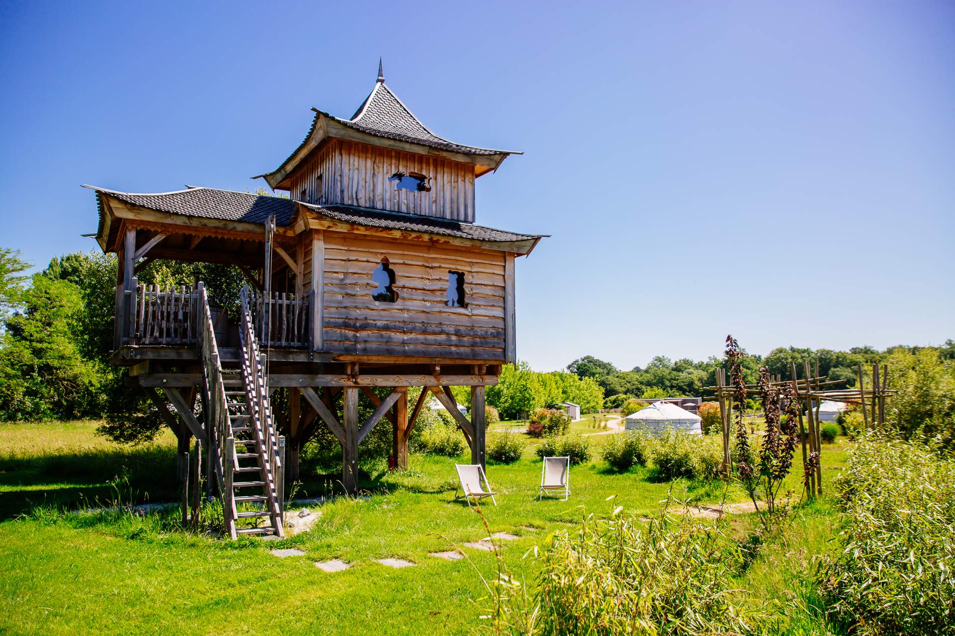 Temple perche avec spa 11 Cabane perchée en bois avec terrasse, entourée de verdure en Aquitaine.