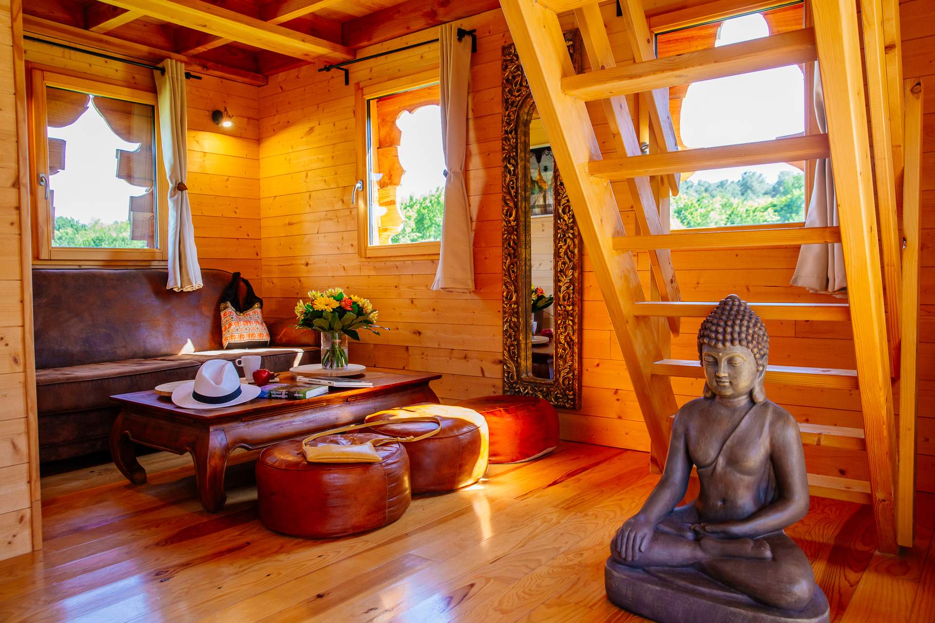 Temple perche avec spa 5 Cabane en bois avec un intérieur chaleureux et une statue de Bouddha décorative.
