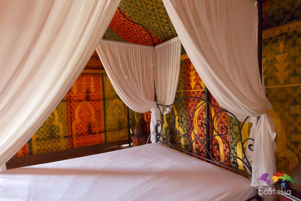 Tente Caidale 3 Tente berbère colorée avec lit en fer forgé, ambiance chaleureuse et accueillante.