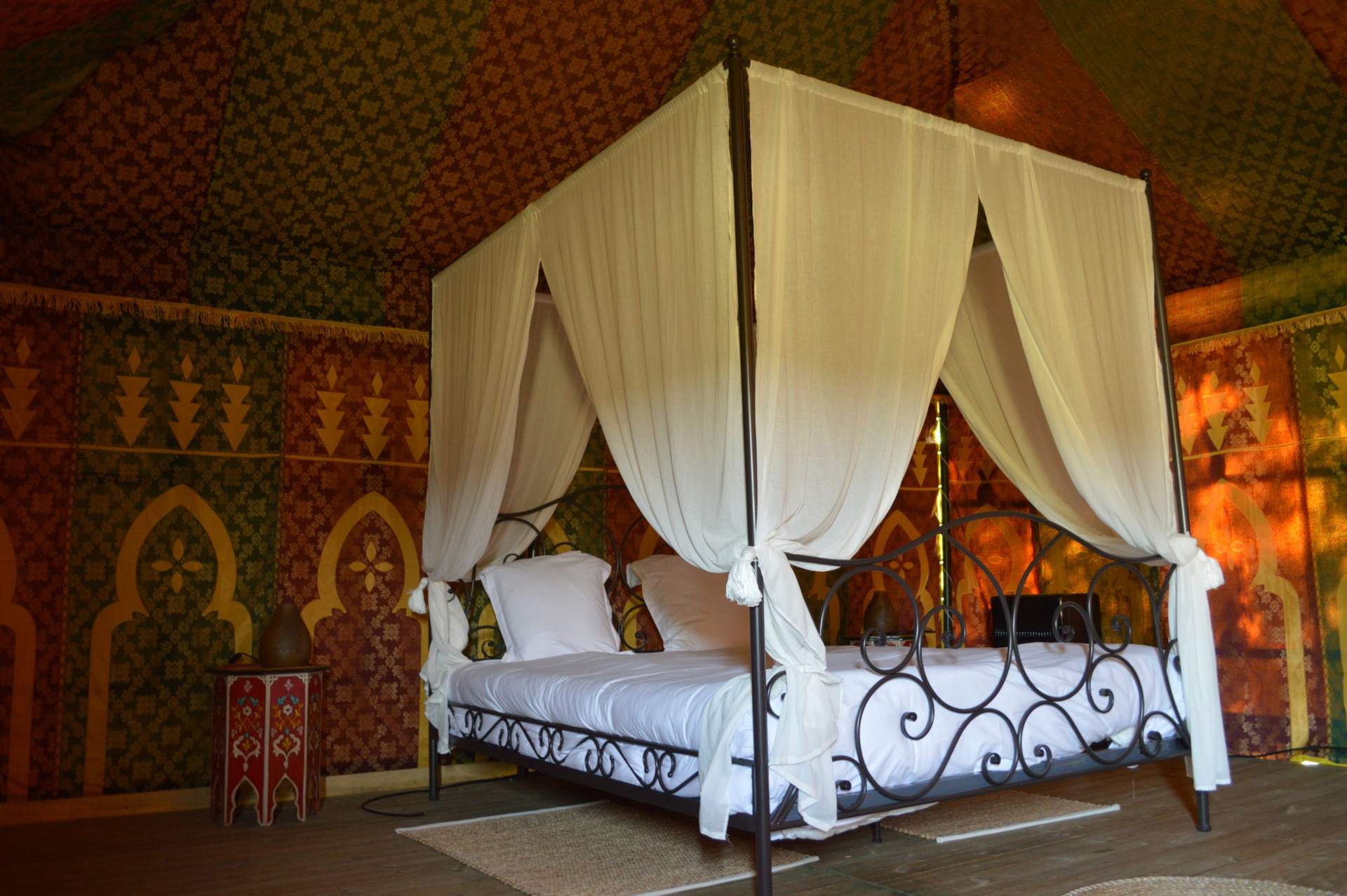 Tente Caidale 4 Tente luxueuse en Aquitaine, lit à baldaquin et décoration colorée.