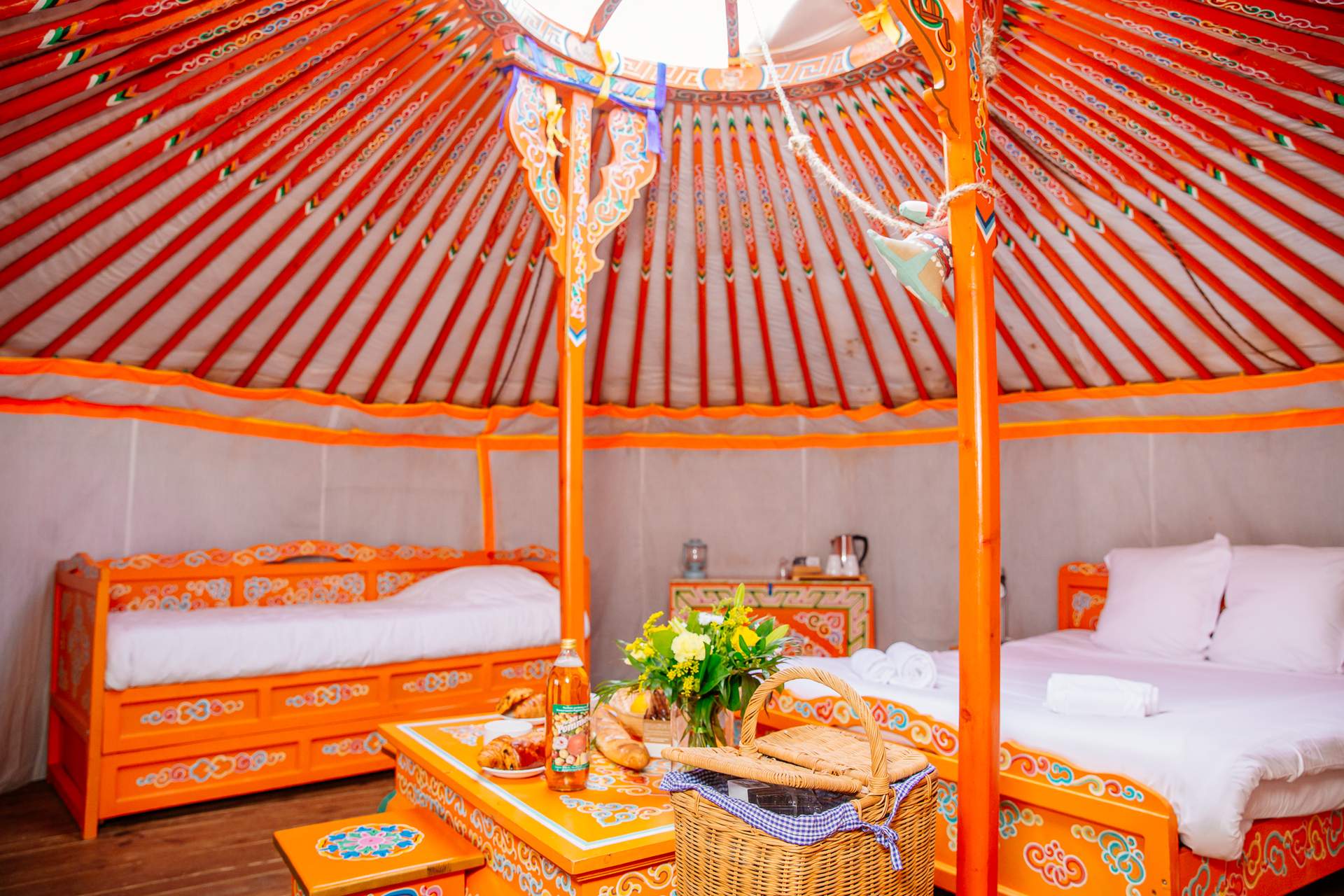 Yourte 6 Yourte colorée en Aquitaine, avec des lits en bois et une décoration traditionnelle.