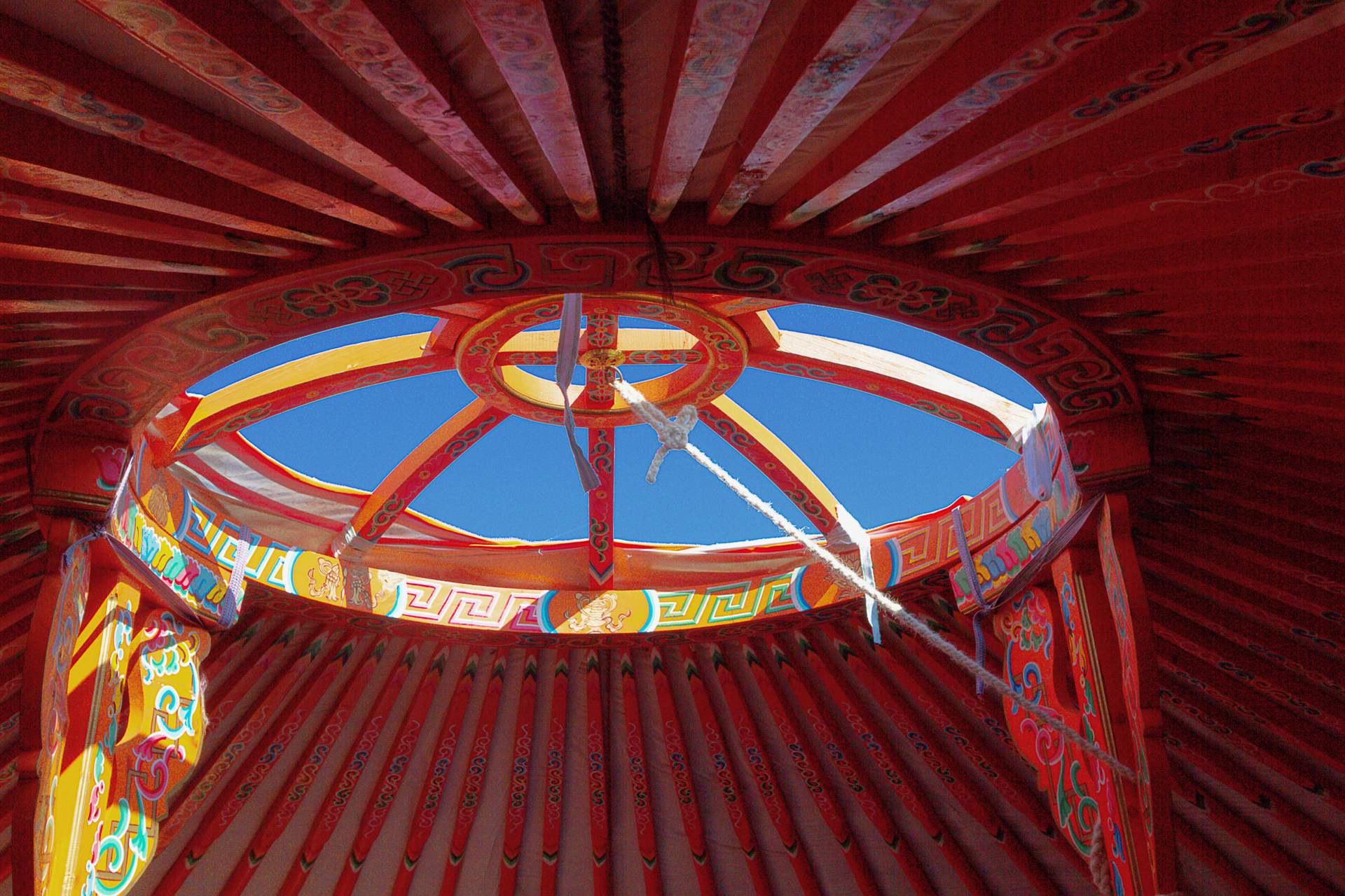 Yourte 8 Intérieur coloré dune yourte en Aquitaine, avec un ciel bleu visible par louverture.