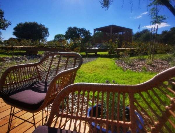 Hébergement insolite en Languedoc-Roussillon, avec chaises en rotin et vue sur la nature.